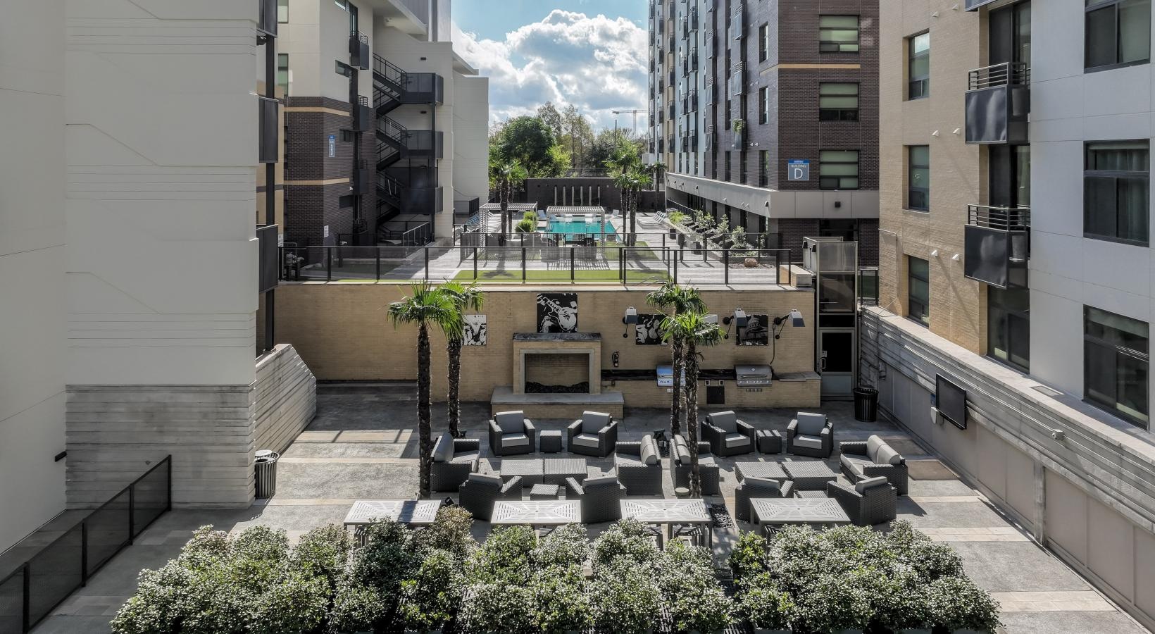 Settle into comfort at Berkshire Riverview a courtyard with chairs and plants in it and buildings around it